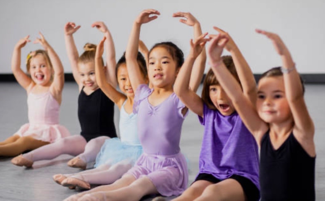 Young dancers stretching together in class